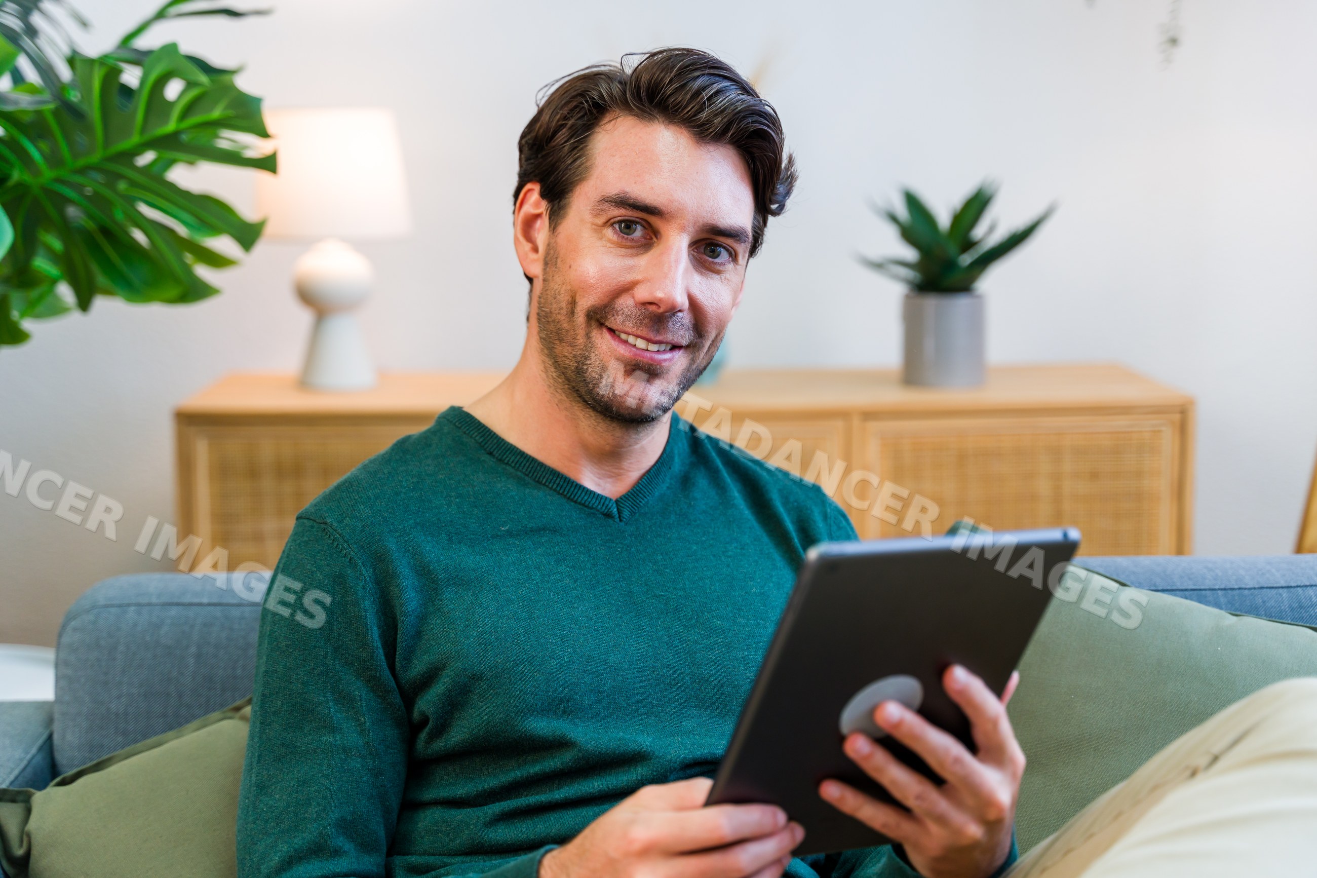 White man using tablet in modern indoor living room
