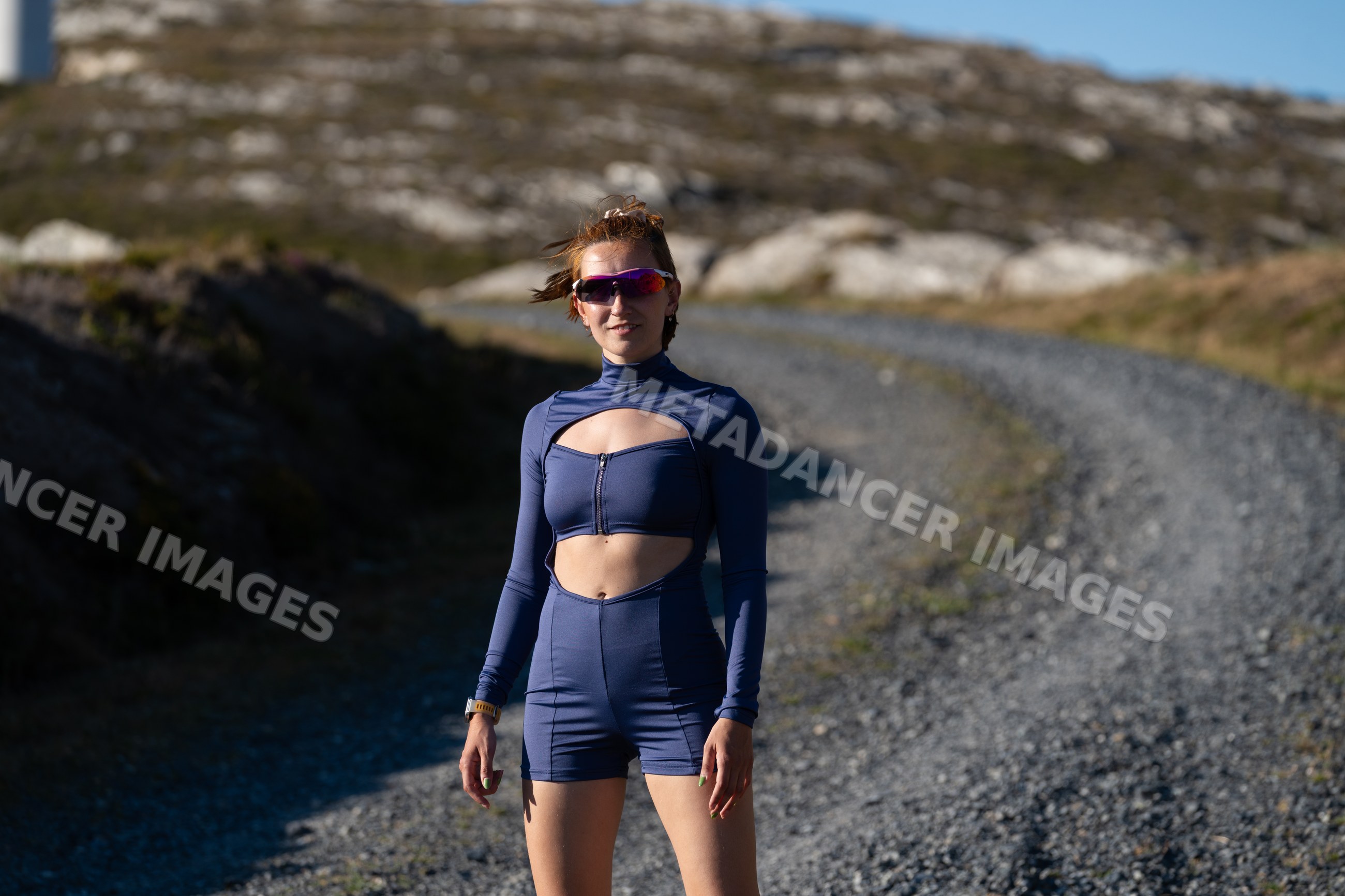 A white woman stands outdoors on a gravel trail in Galicia, Spain