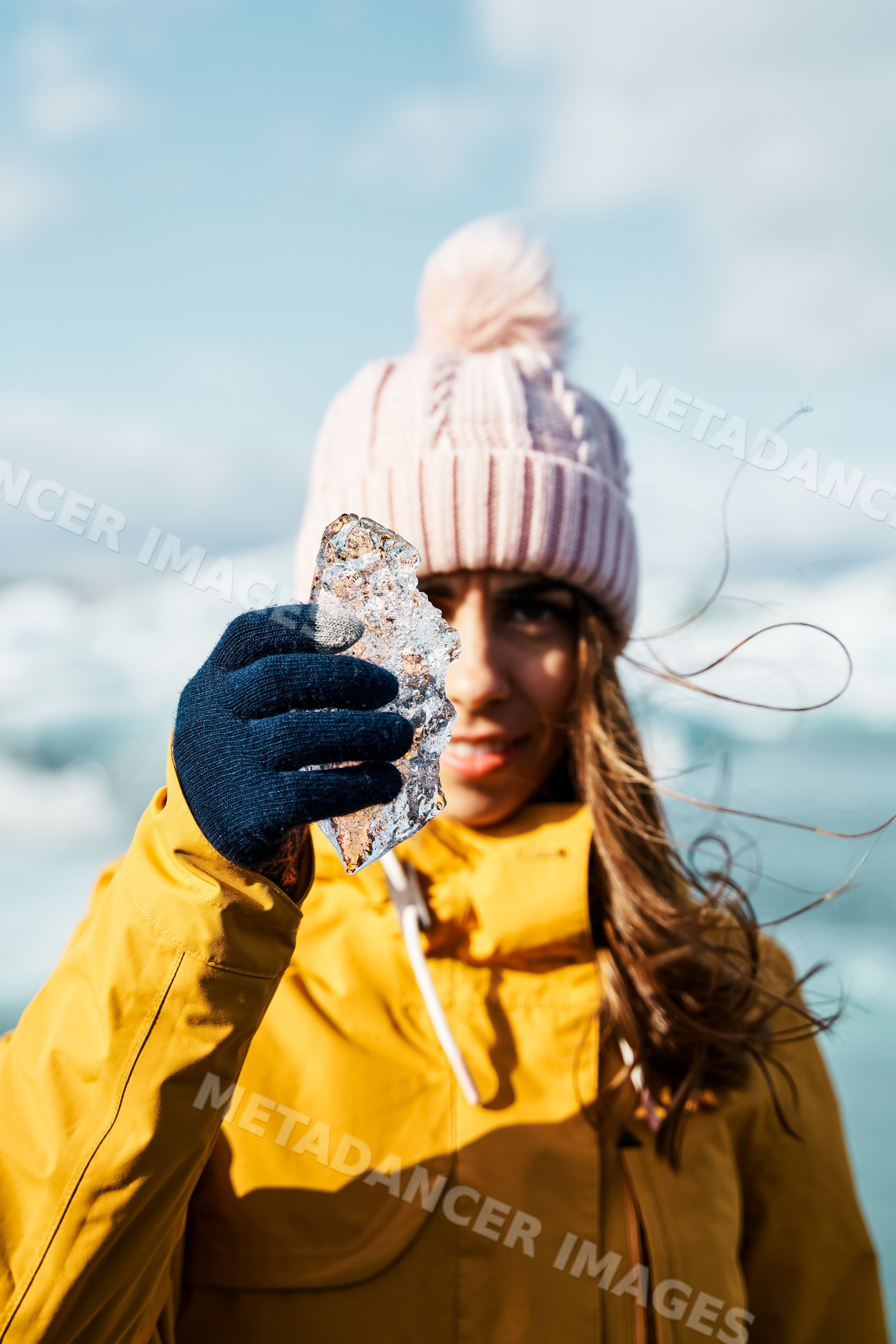 A white woman holding a piece of ice outdoors