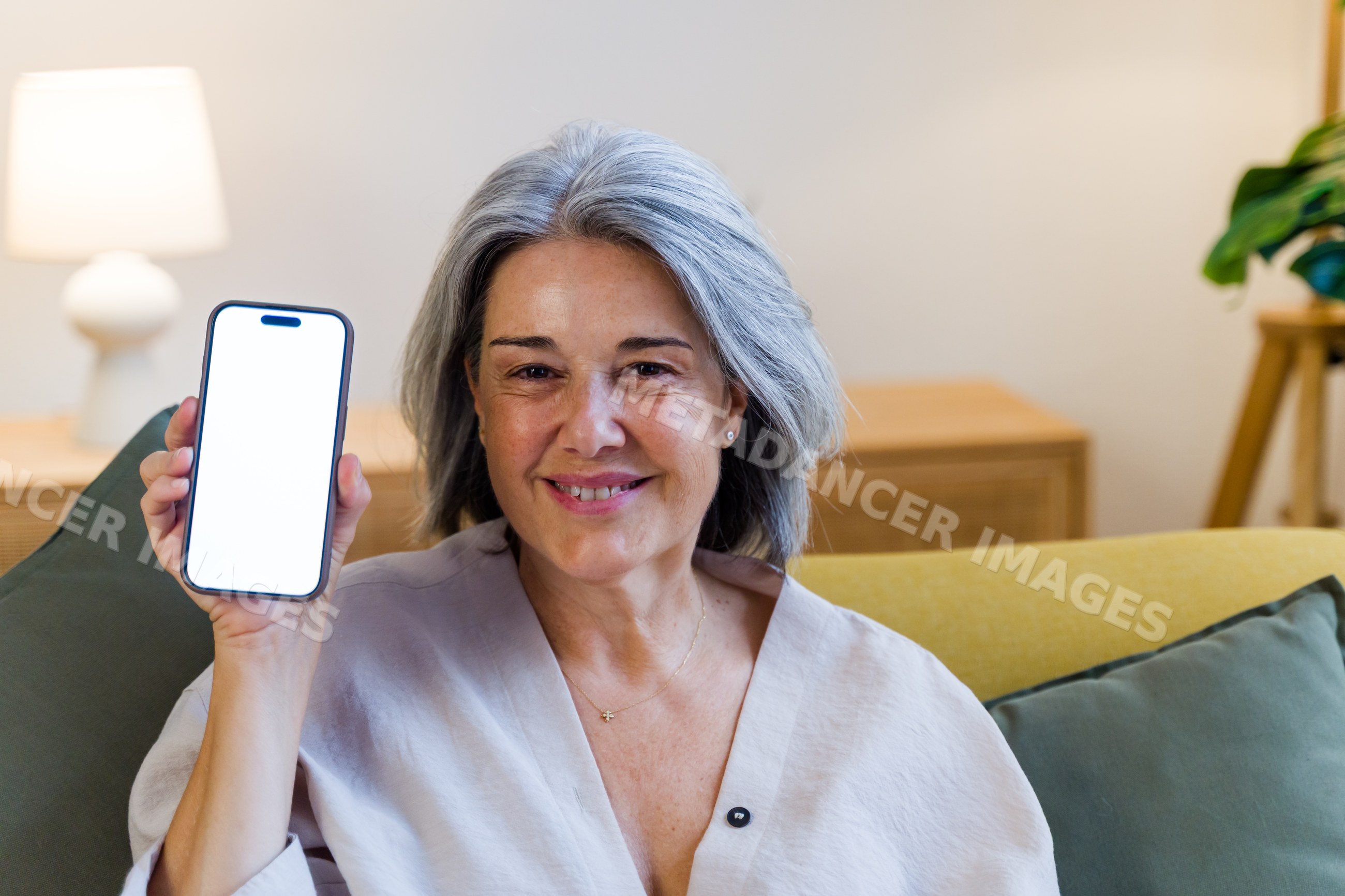 Mature white woman holding smartphone with blank screen