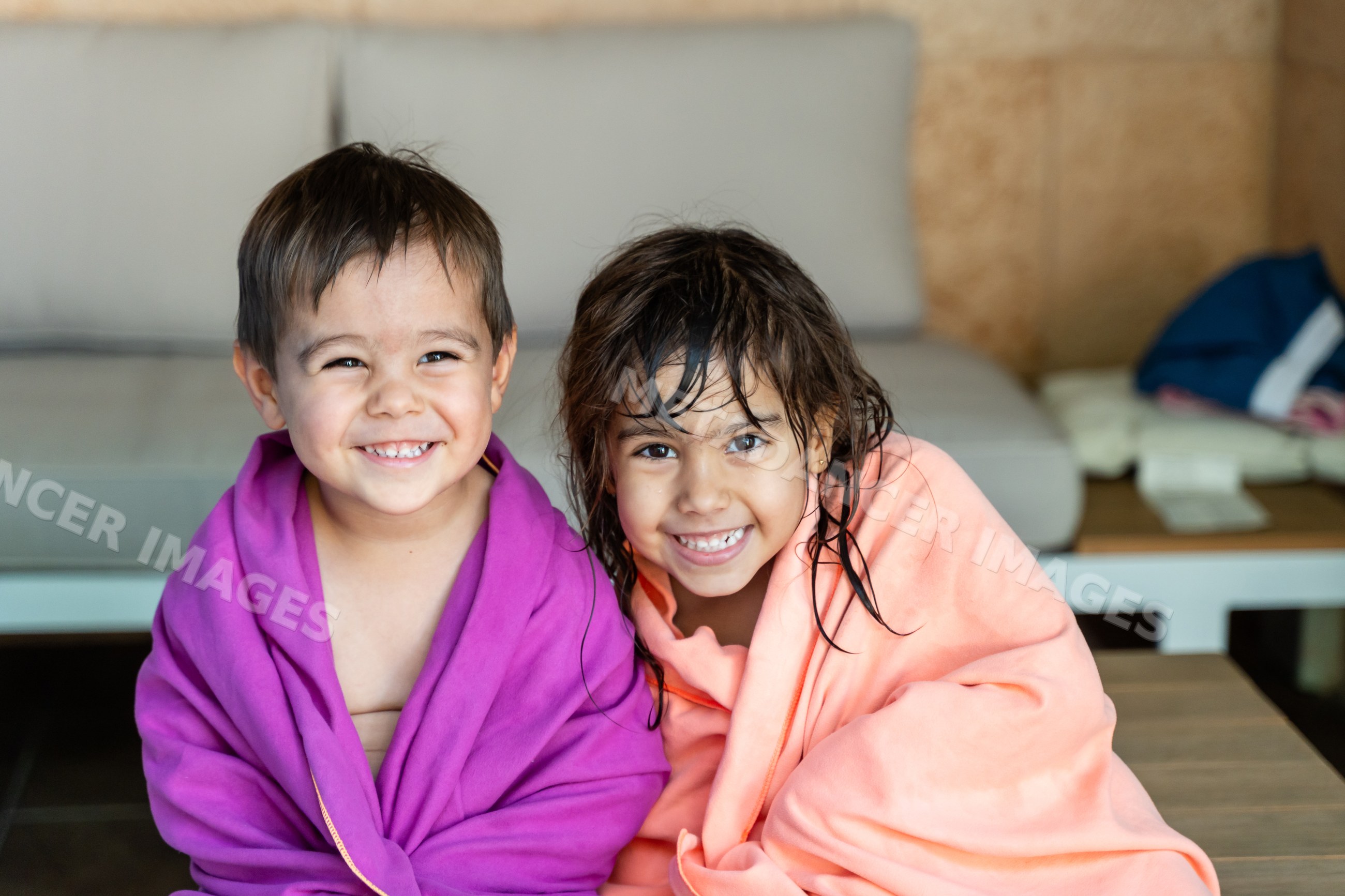 Two smiling white children wrapped