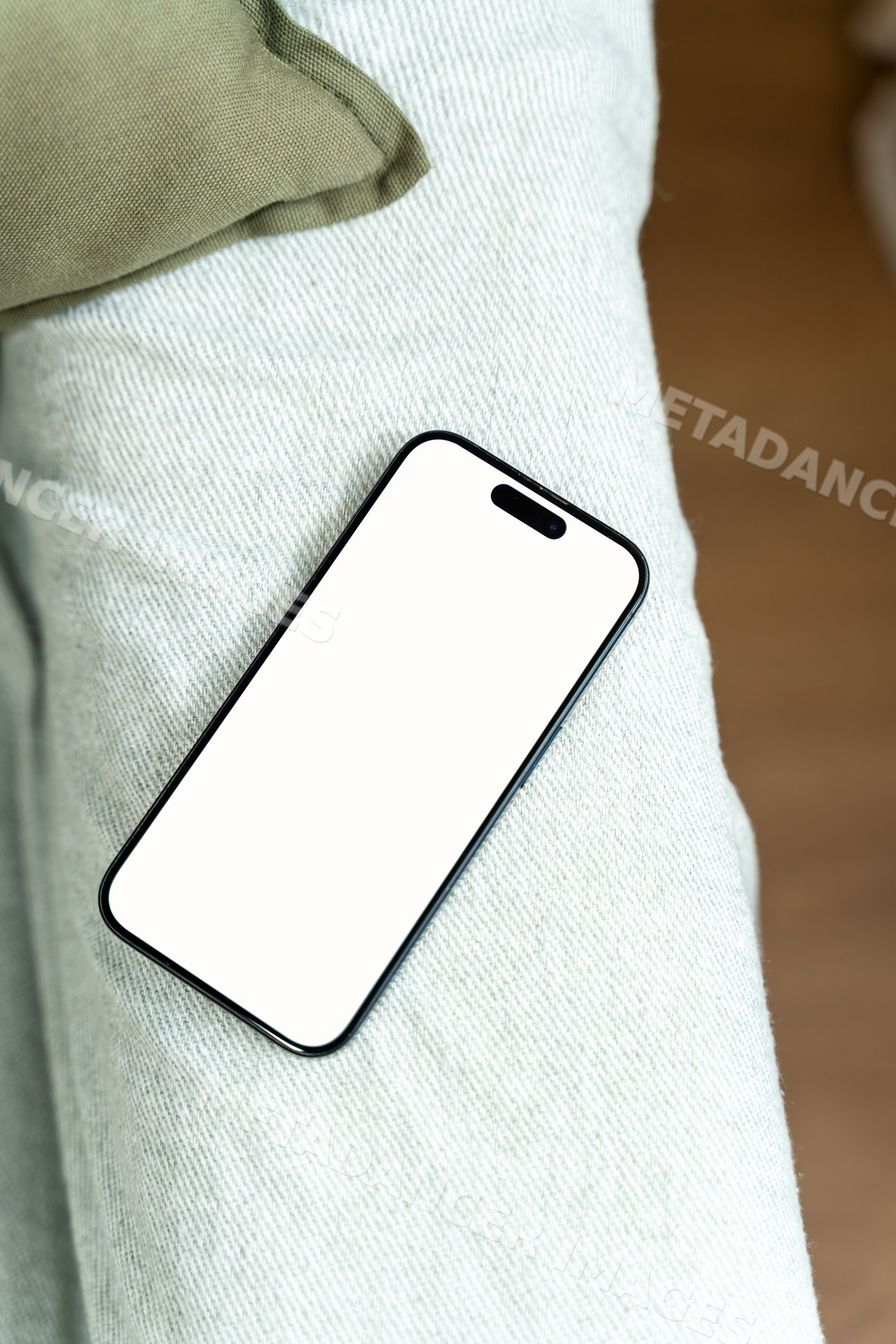 Smartphone with blank white screen resting on textile surface