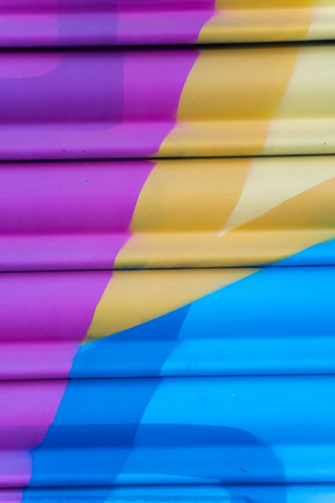 Abstract colorful paint texture on corrugated metal surface