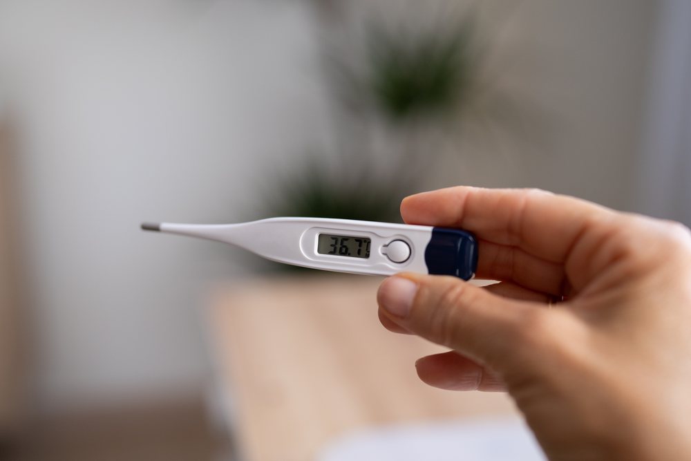 Digital thermometer measuring body temperature indoors