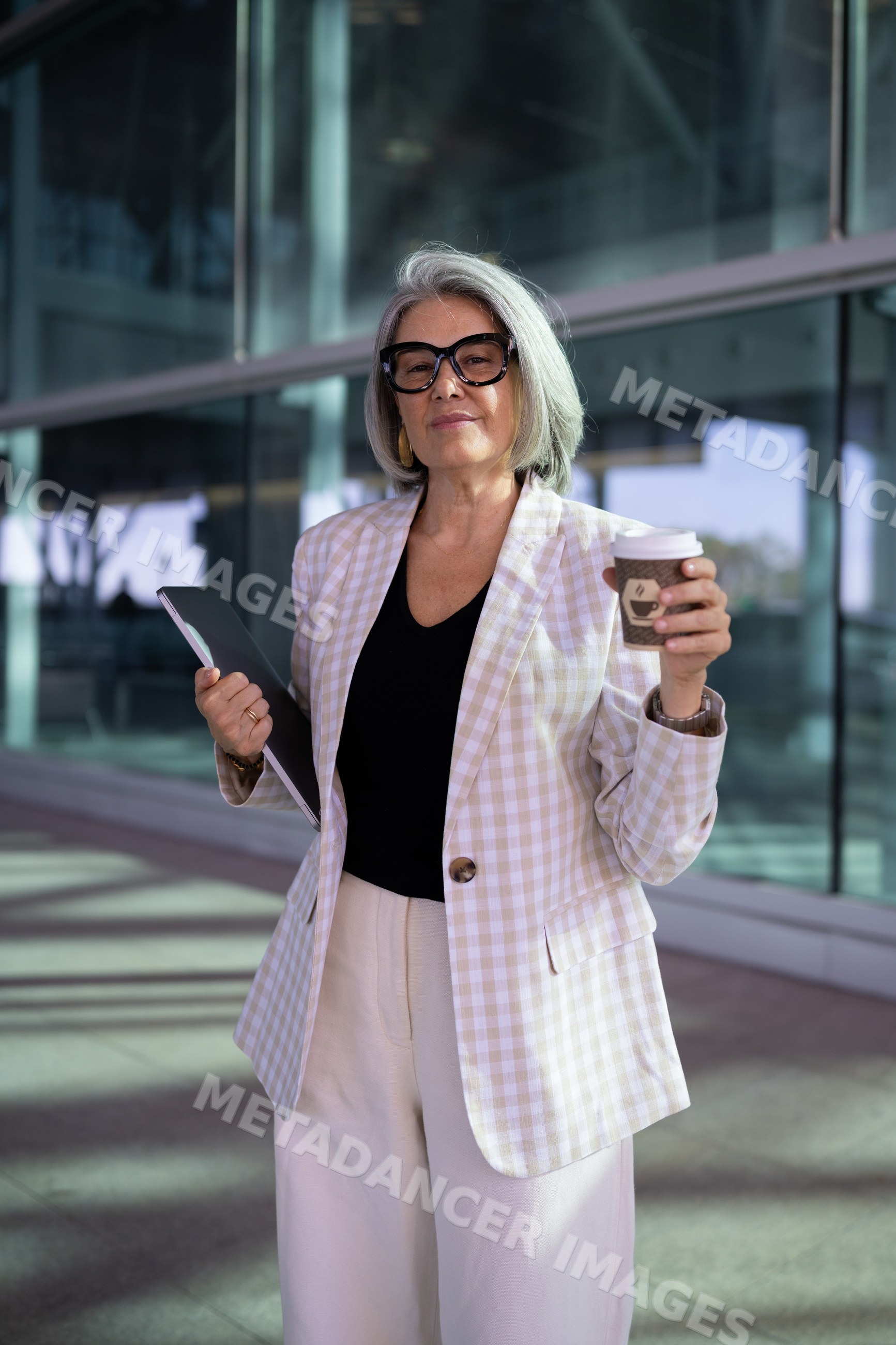Businesswoman tablet computer and coffee cup outside modern building