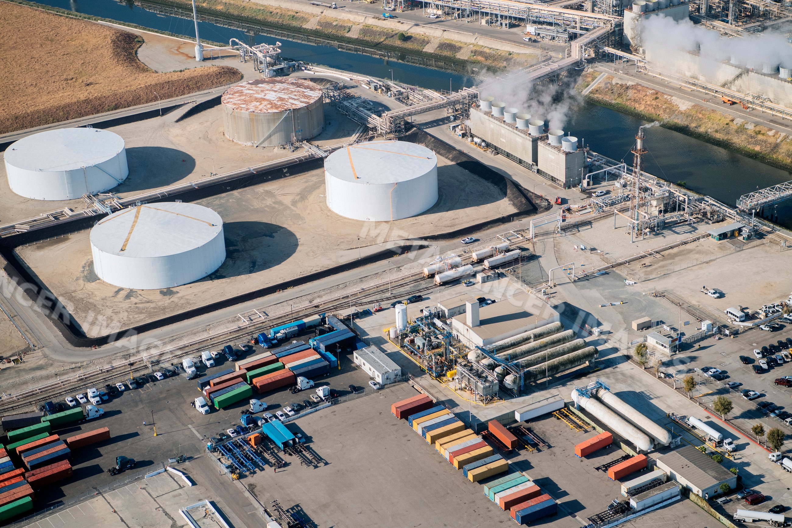 Industrial facility with oil storage tanks and shipping containers